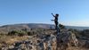 Child on top of a rock plays with a Kite