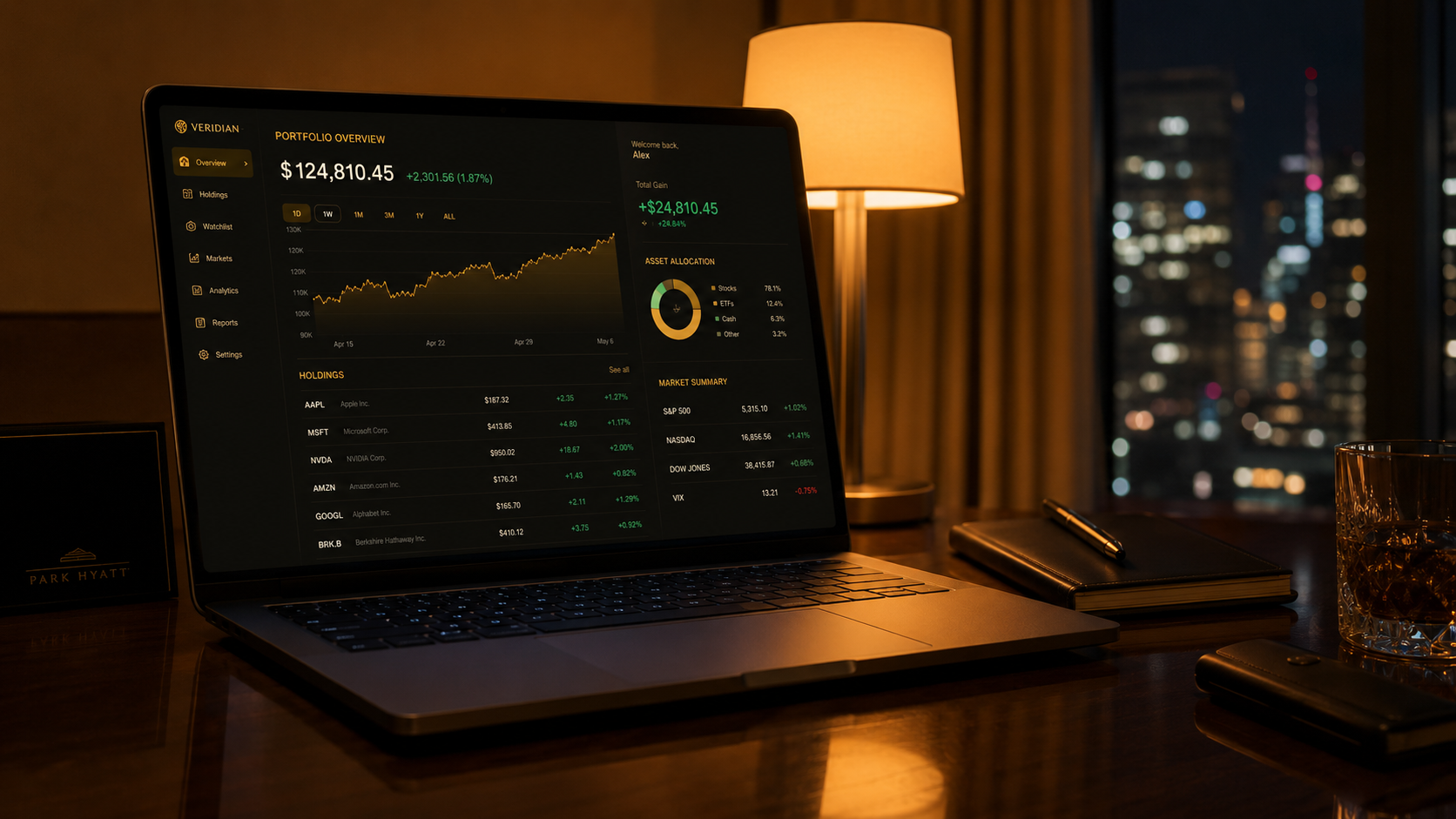 Open laptop on a hotel room desk at night showing a stock portfolio dashboard, warm desk lamp, soft city lights through the window
