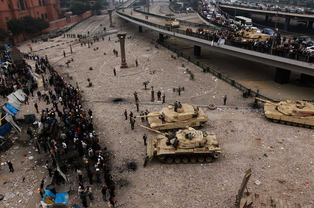 2011年2月5日，埃及開羅，埃及軍隊以坦克和刀片刺網分隔在解放廣場的反政府示威者及穆巴拉克支持者。攝：Chris Hondros/Getty