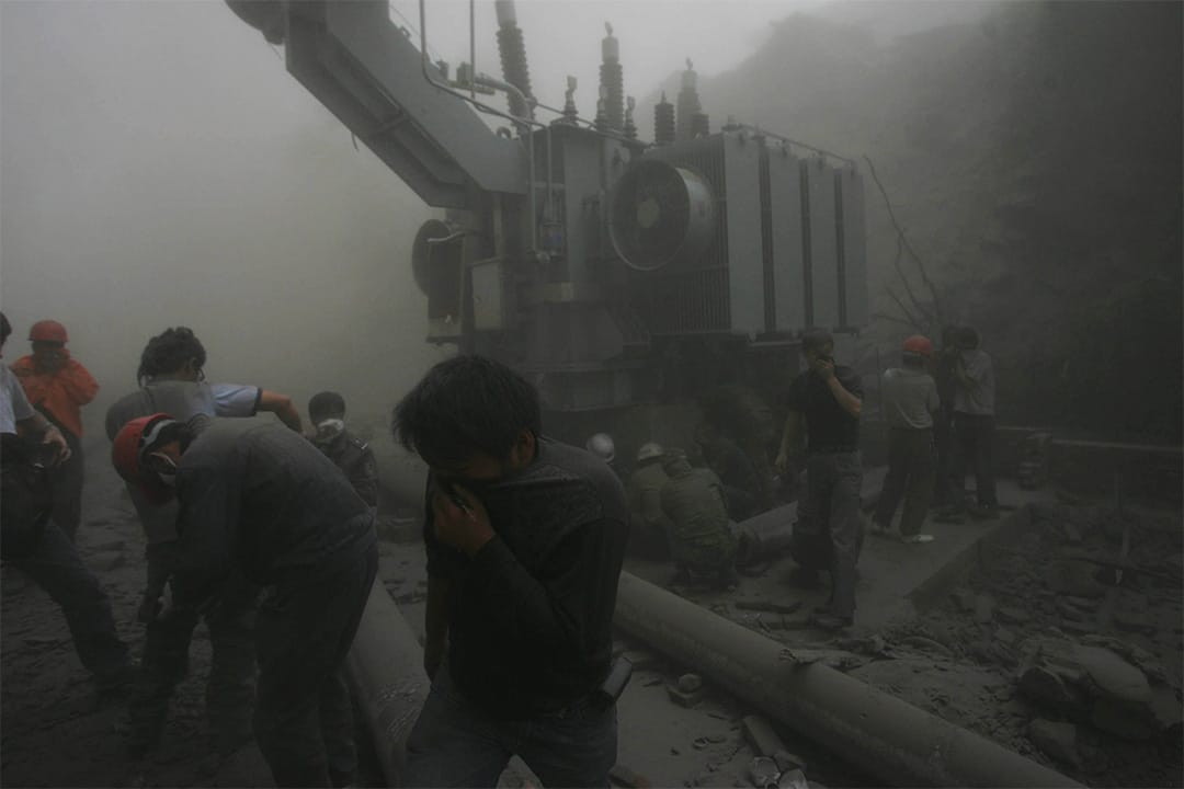 2008年5月17日，生还者和救援人员在躲避余震引起的山泥倾泻。