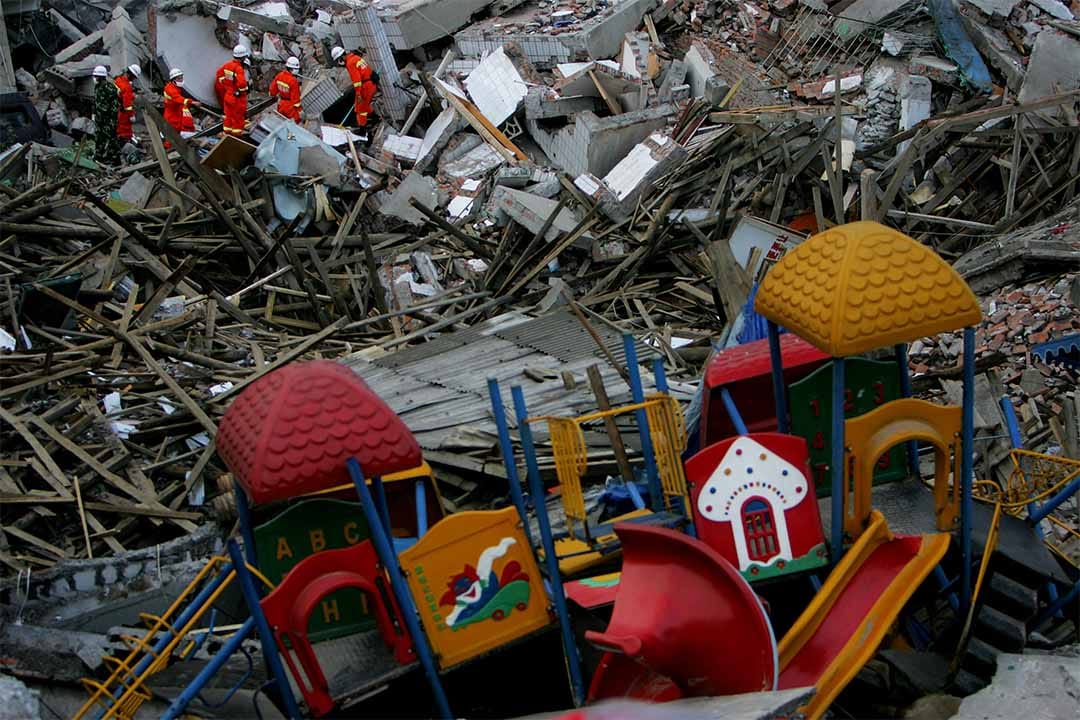 2008年5月14日，中国士兵在绵阳市一间倒塌幼稚园遗址中搜救生还儿​​童。