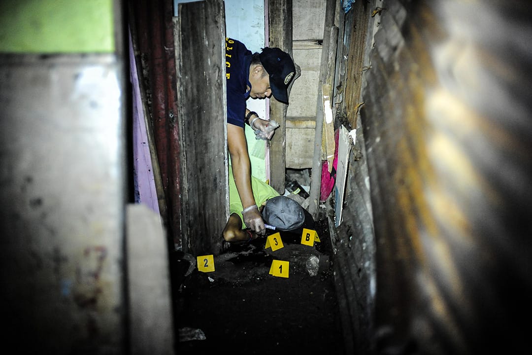 2016年6月25日，菲律賓馬尼拉，三名毒販被槍殺後，法醫檢查其中一具屍體。