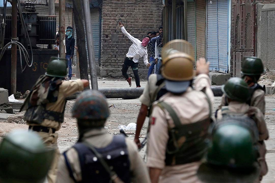 一名穆斯林示威者向印度警察投擲石頭。 