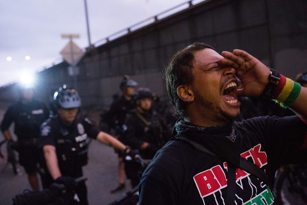 一名示威者在西雅图示威现场,在警察前面叫喊。