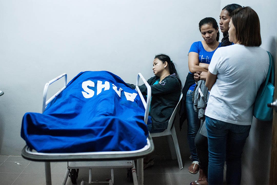 2016年8月20日，菲律賓馬尼拉，家屬站在一個警員的屍體旁。