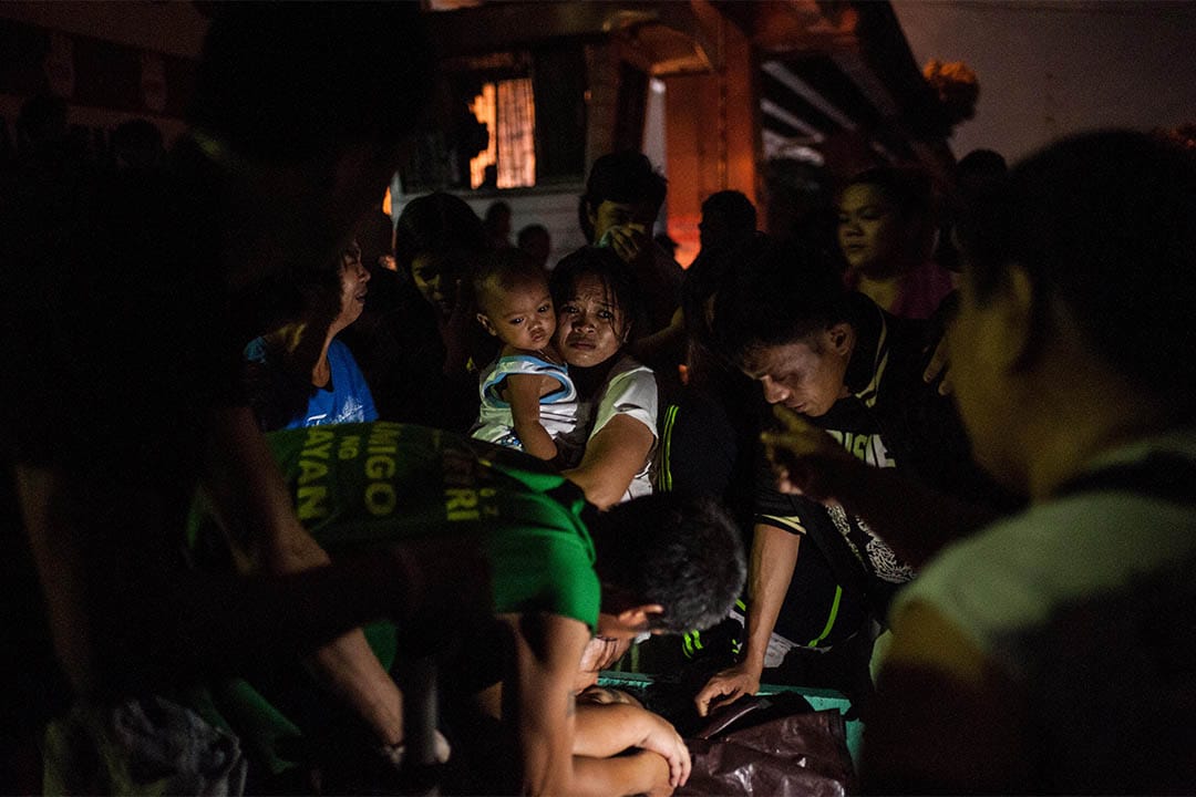 2016年8月17日，菲律賓馬尼拉，家屬圍著一個被疑為毒販者的屍體。