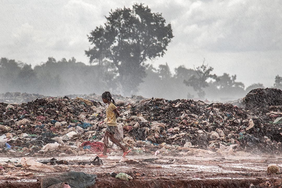 柬埔寨暹粒，一位女孩在暴風過後的垃圾堆中奔跑。