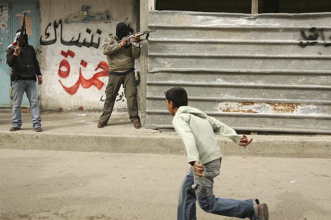 加沙地區，一名孩子在當地親政府維和部隊與哈馬斯戰士開火時逃跑。