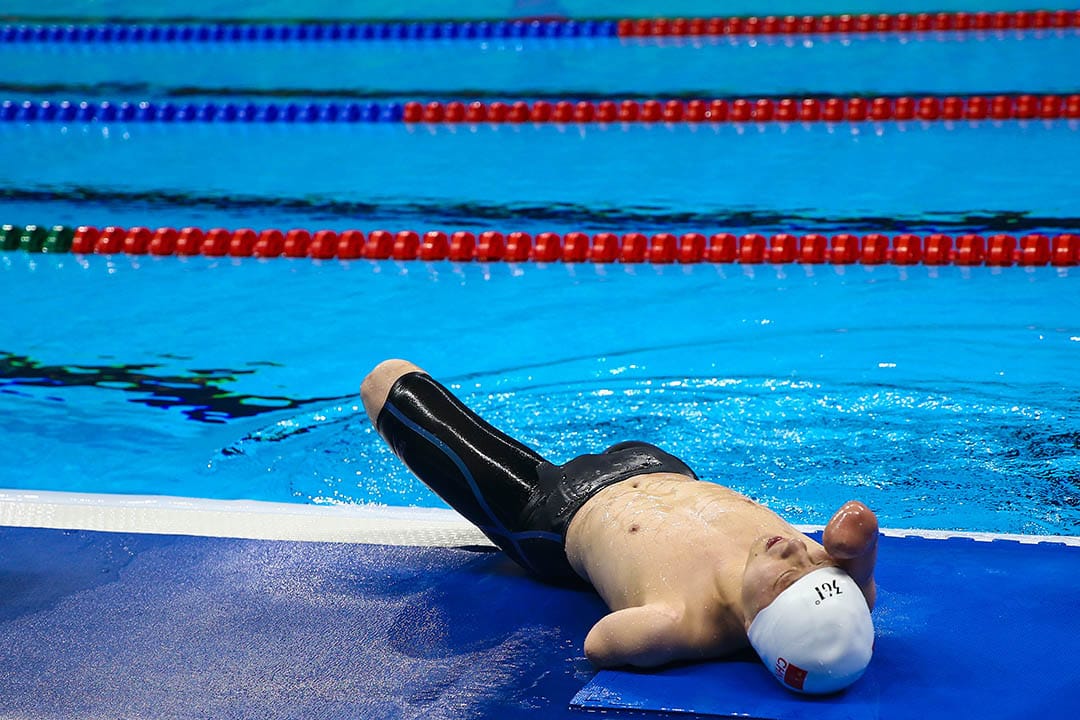 中国选手许庆在比完男子200公尺个人混合式后在池边休息。