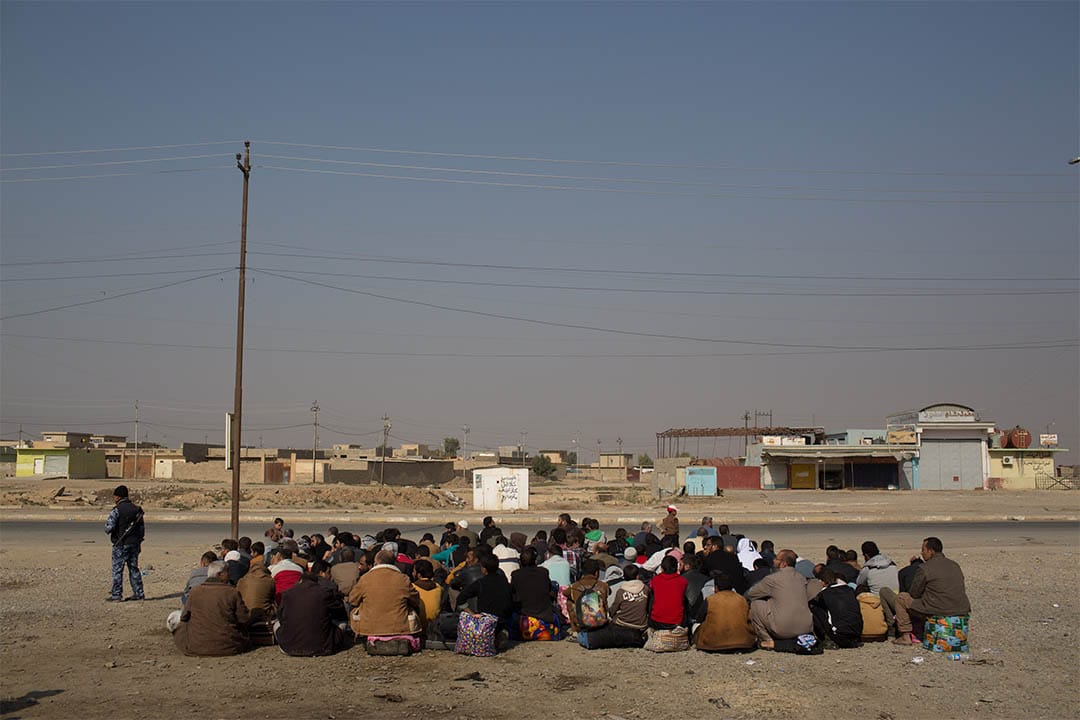 2016年11月7日，伊拉克高吉亞利，一群男士等待車輛前往國內流離失所者營地。