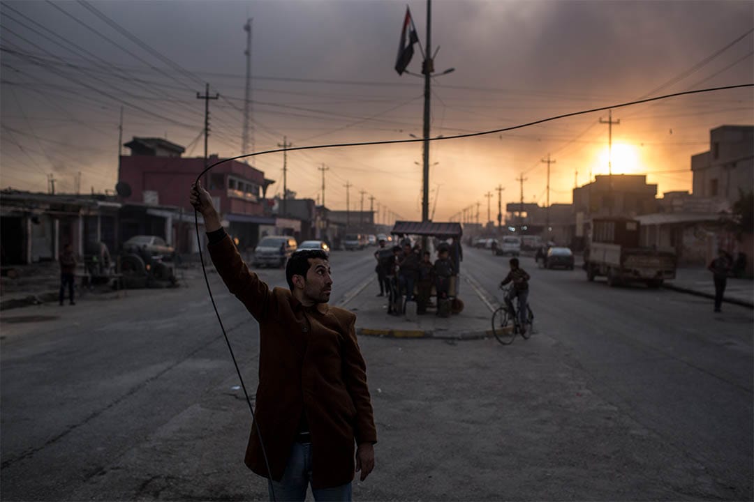 2016年11月9日，伊拉克蓋亞拉，一個男人手抓住電纜。