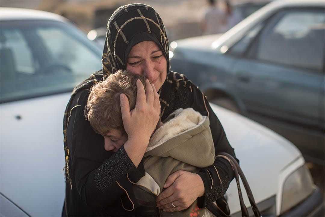 2016年11月7日，伊拉克高吉亞利，一個女人回到家鄉後緊抱著分隔兩年多的孩子。