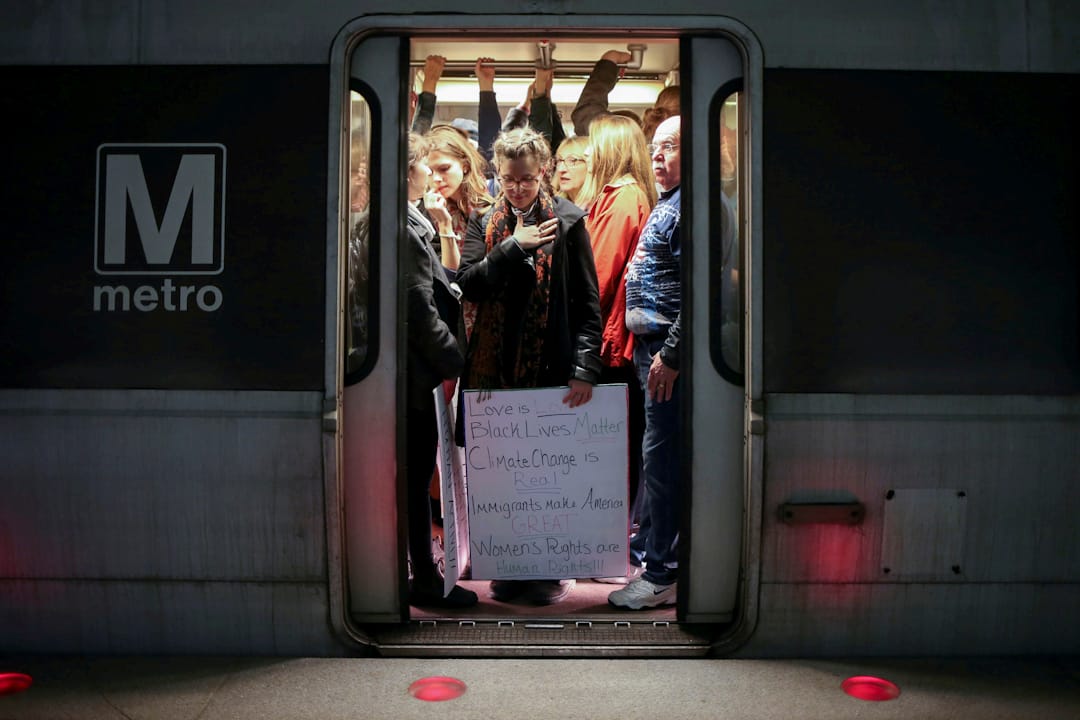 在美國華盛頓，拿着標語的女士正乘坐地鐵前往示威區。