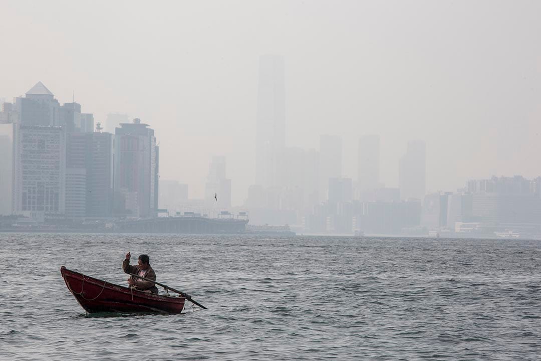 在鲤鱼门对出海面，一名男子在划船垂钓。