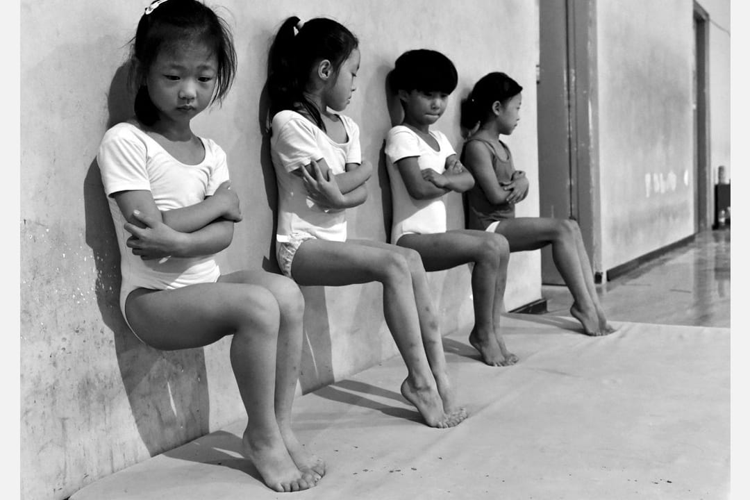 在中国徐州一所体操学校内，四名体操学生正在做脚趾压力训练。