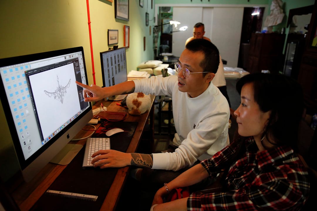 纹身师史海雷跟Eason讲解纹身图案。