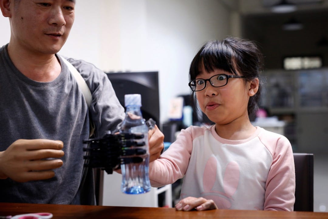 戴上义肢的Angel尝试拿起水樽。