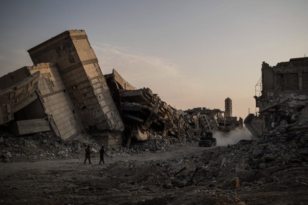 2017年7月9日,伊拉克政府軍成員行經摩蘇爾舊城區的破爛街道。