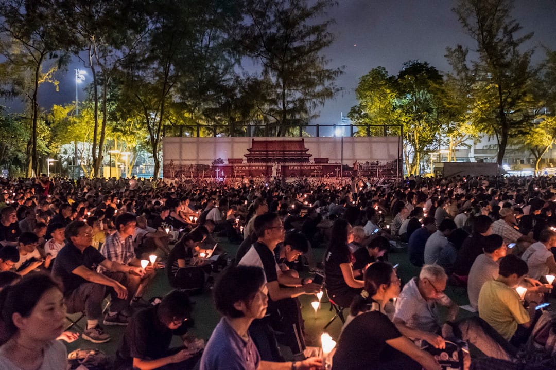 2017年6月4日,香港維園舉行六四晚會。參與者在天安門廣場的大橫幅旁,手持燭台,悼念天安門事件中的死難者。