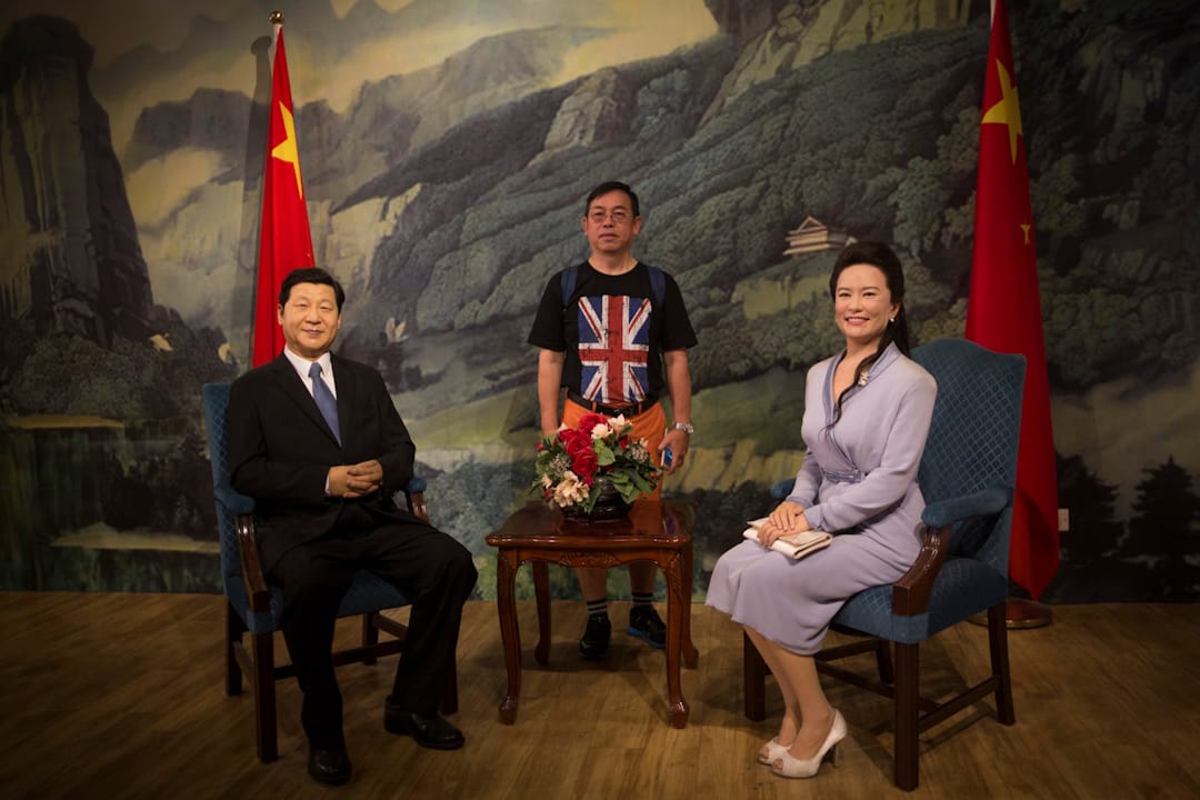 2017年7月1日，香港回歸20年之際，香港杜莎夫人蠟像館中，一位身穿印有英國國旗的T恤的市民和國家主席習近平及其夫人彭麗媛的蠟像合影。