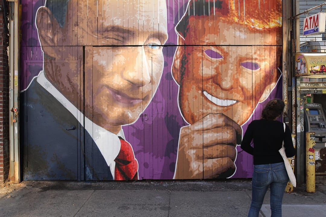 2017年2月25日，在美國紐約市布魯克林區，一名途人行經一個畫上了俄羅斯總統普京拿著特朗普面具的店鋪門口。