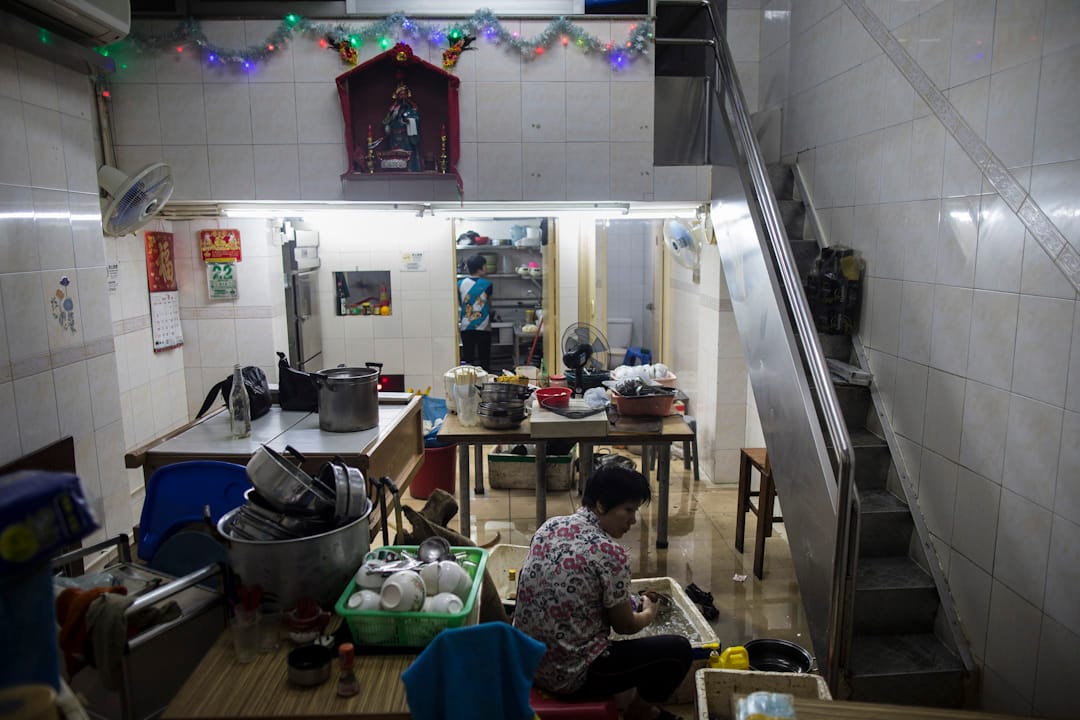 澳门遭台风“天鸽”吹袭，多区出现严重水浸，一间店舖的居民正在清理积水及执拾。