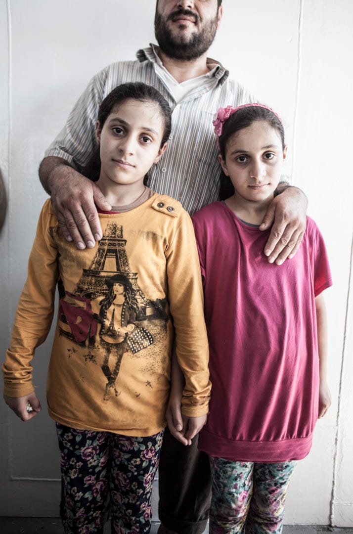 9歲的雙胞胎 Aziza 和 Afra,和因為害怕巴沙爾政權逼害而不想被拍攝的爸爸。