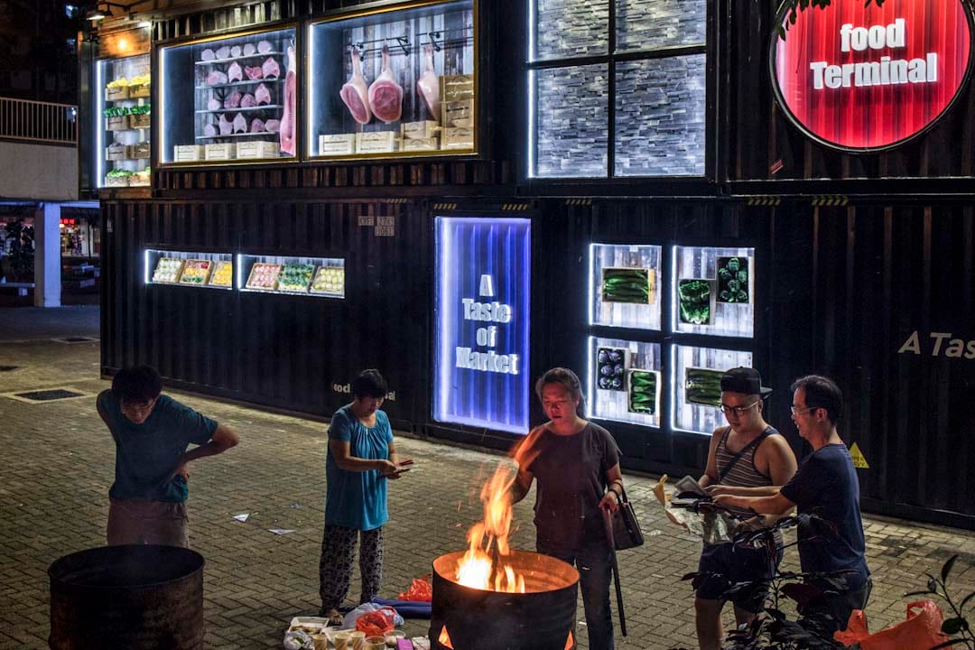 農曆七月十四前夕，居民於啟業邨街市外燒街衣，剛裝修的街市，以貨櫃箱的形式設計大門。該區為舊 式公共屋邨，住了不少基層長者。