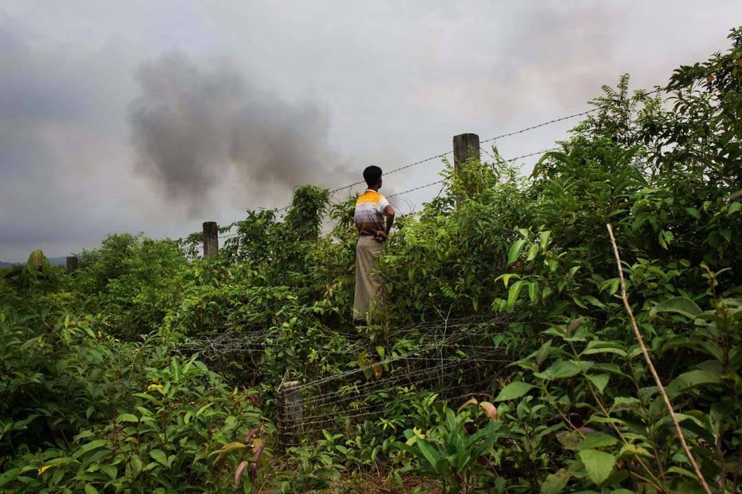 2017年9月4日，一名羅興亞人在孟加拉邊境的一道鐵絲網圍欄前遠觀緬甸。