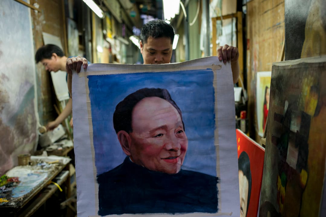 大芬村一條巷子裏，一個畫家正在展示他正在打草稿的鄧小平肖像。