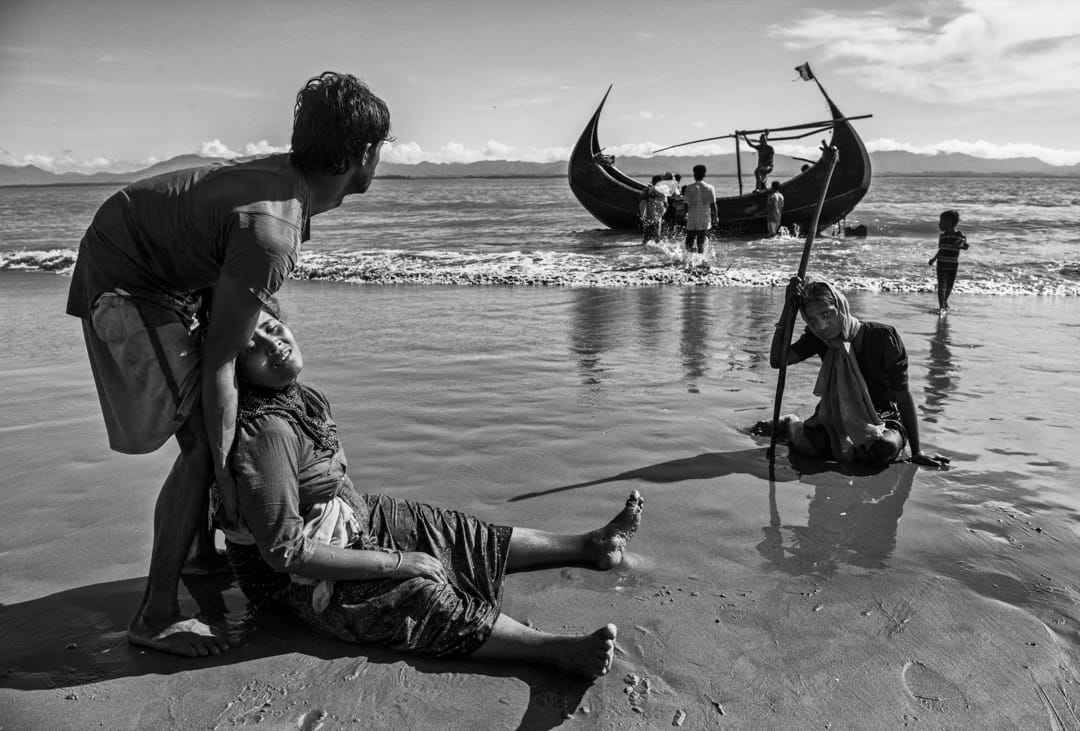 2017年10月1日，在越过缅孟边境的纳夫河后，一名筋歇力疲的罗兴亚妇人倒卧在科克斯巴扎尔县的沙滩上。