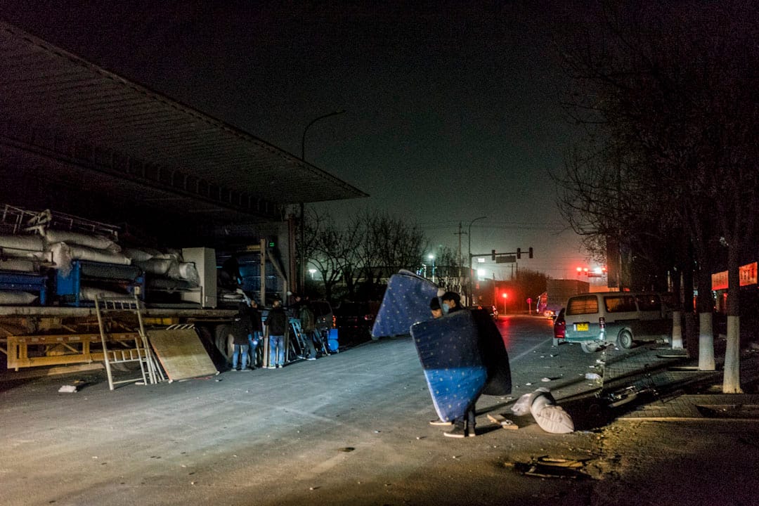 2017年11月25日晚上，工人將床墊搬到馬路對面的卡車上，之後他們將到遠離北京的新廠區安置。