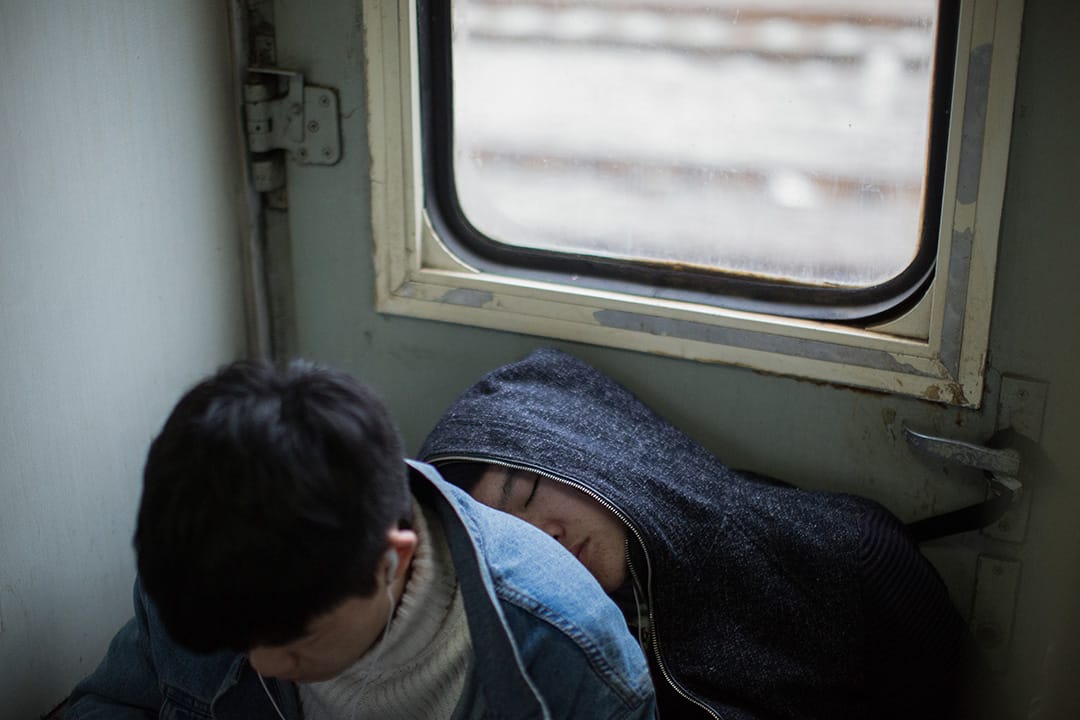 少年依偎在一起,睡在車廂地上。