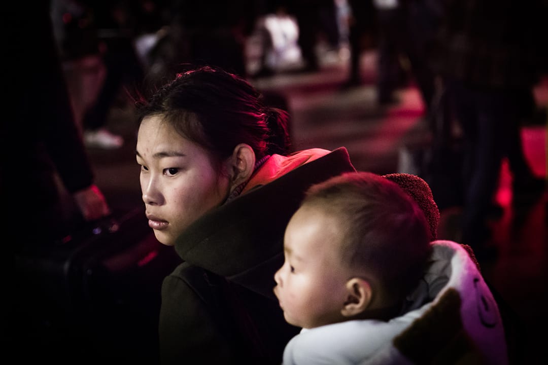 廣州車站外,一對母子等待進入火車站。