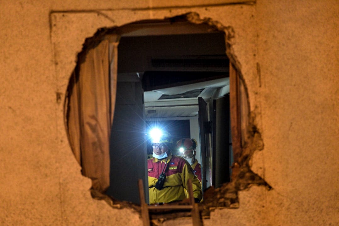 凌晨三時，消防員在災情嚴重的統帥大飯店現場搜索生還者。 