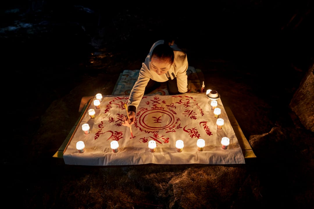 韩国江原道，萨满法师Nunkotsunnyu在头陀山的一个山洞里，用动物血画护身符。