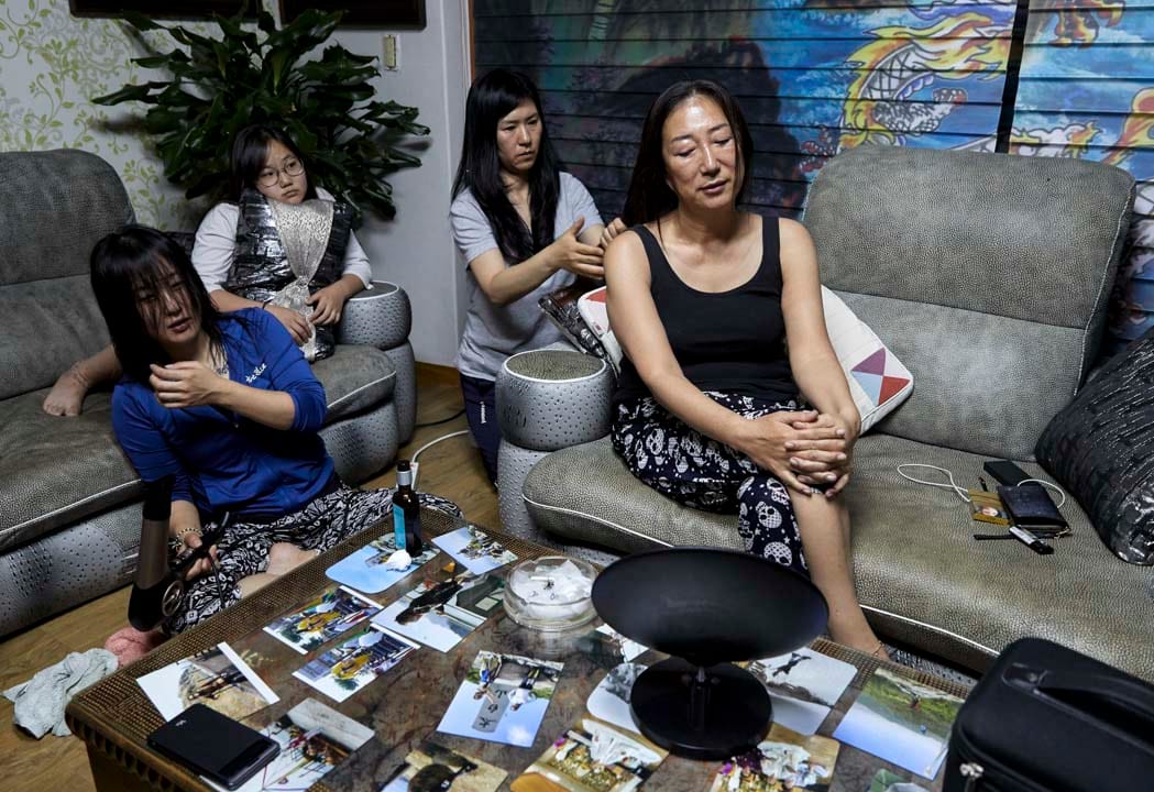 韩国堤川市，萨满法师Cheonsindangju闭著眼享受弟子为她梳头。