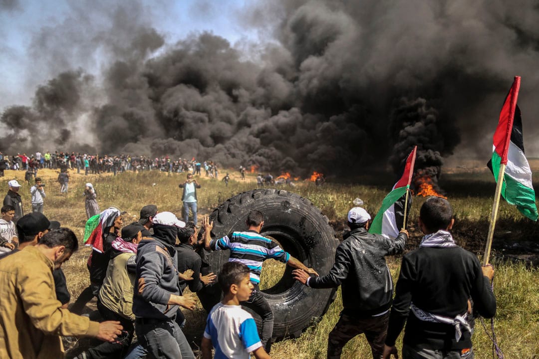 示威者准备焚烧车胎制造黑烟遮挡以色列狙击手的视线。