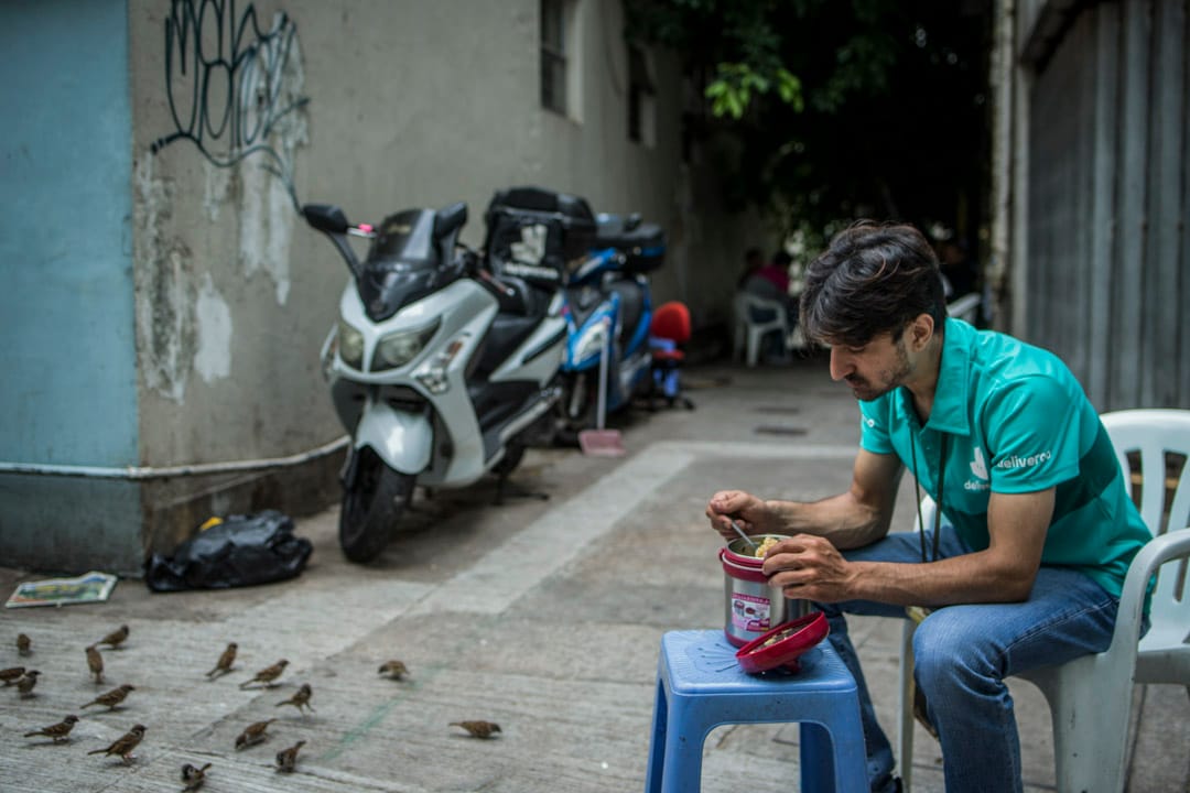 香港出生的巴基斯坦裔Binyamin Benny，任职食物外卖速递车手，他在湾仔的后巷吃午餐，那里是一班车手聚脚休息的地方。他表示工作缺乏基本劳工保障，没有MPF、没有年假、没有劳工保险等，对此他表示不满。