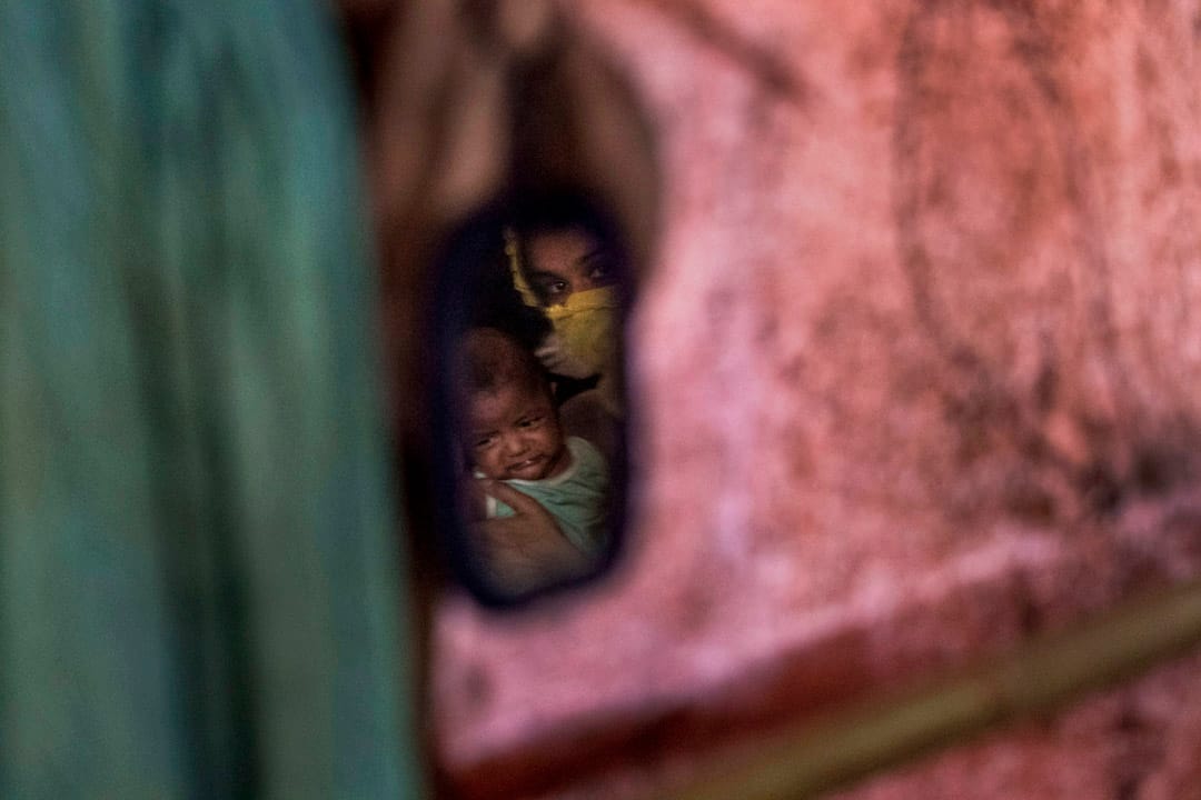 從一面鏡中可見到「M」抱著男嬰。