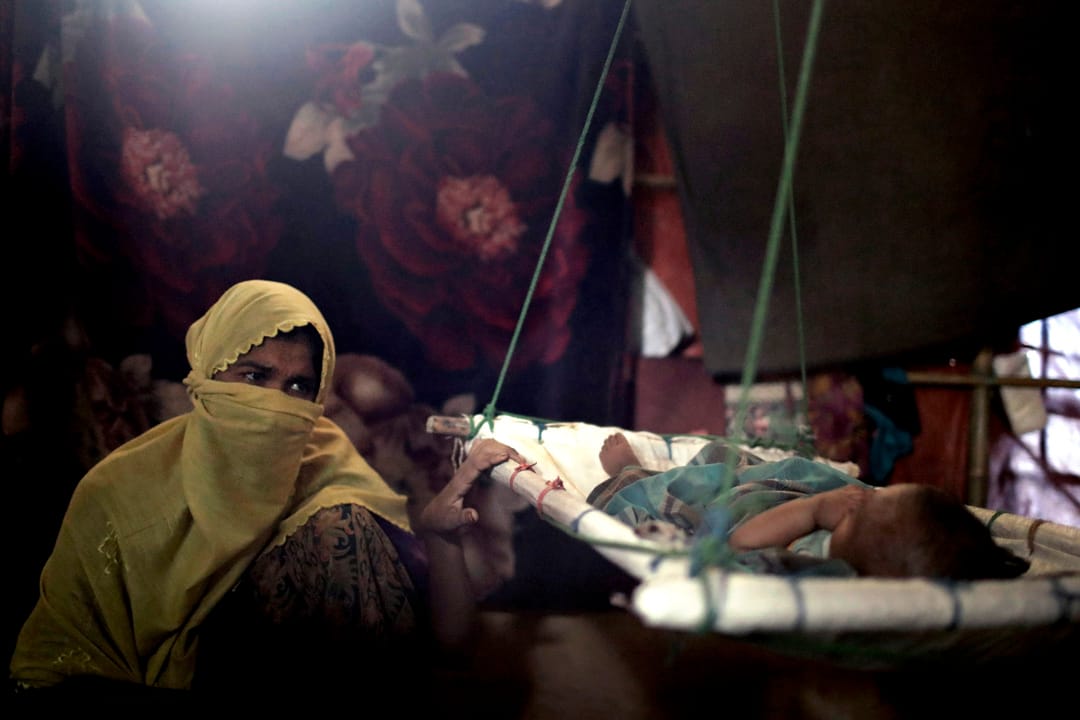 住在Kutupalong難民營的「M」，在帳篷裏晃動著搖籃中、剛誕下不久的男嬰，讓他進睡。