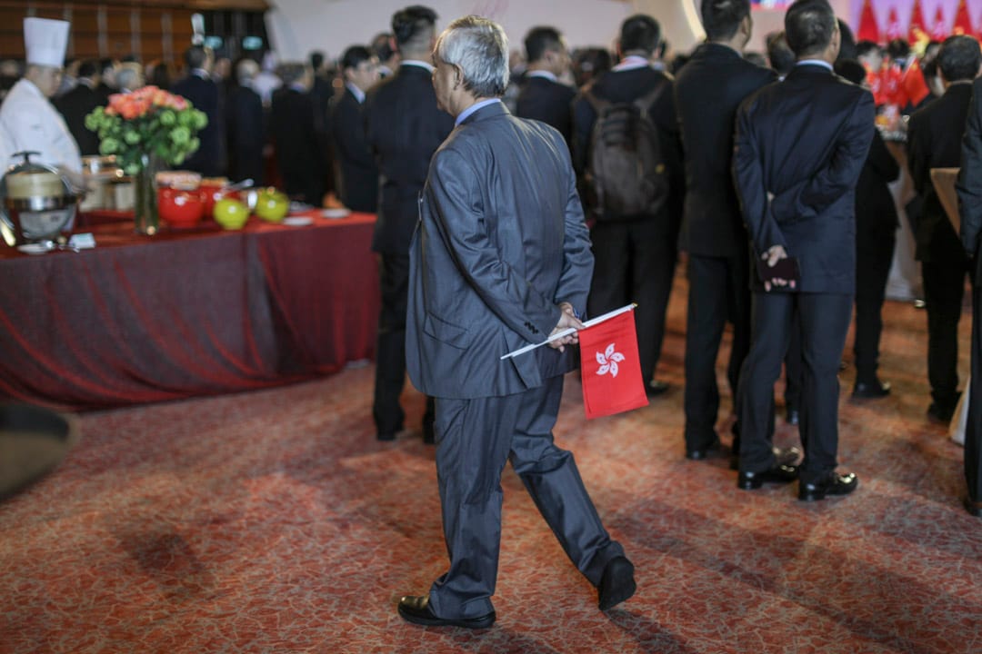 灣仔會展舉行國慶酒會，一名參加者手持香港及中國國旗進場。