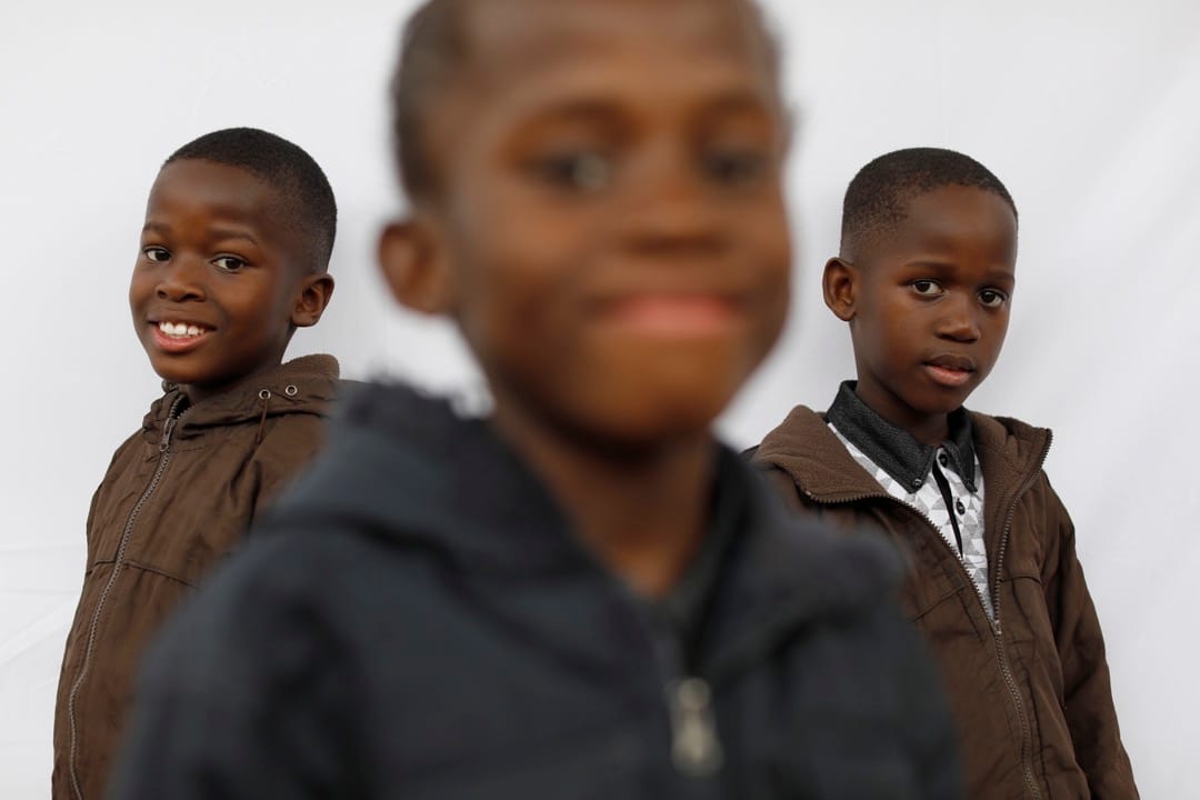 8歲三胞胎兄弟Simphiwe，Syamthende和Sneliswa微笑望向鏡頭。