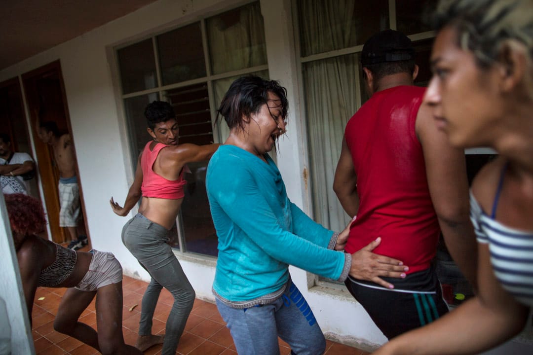 来自中美洲的LGBT移民在当地一家荒废的旅馆外休息，互相打趣跳舞。