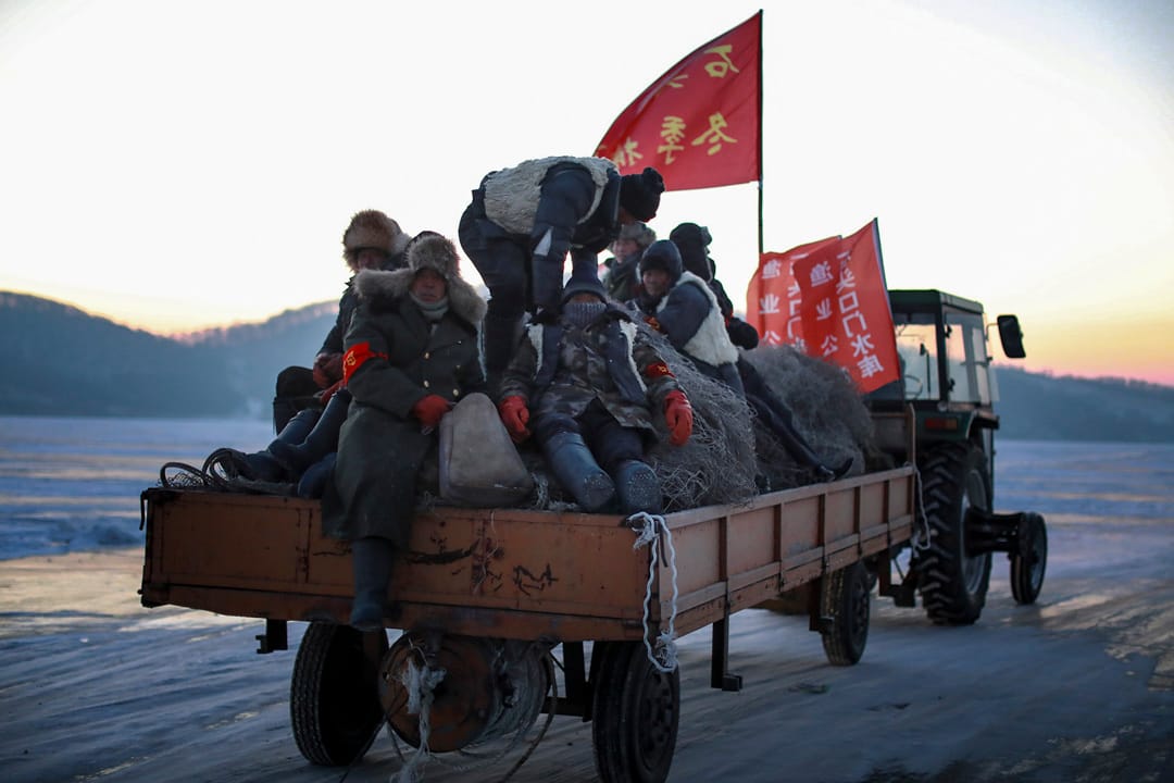 摄氏零下24摄氏，渔民穿上厚厚的大衣，乘坐拖拉机在冰上行走。