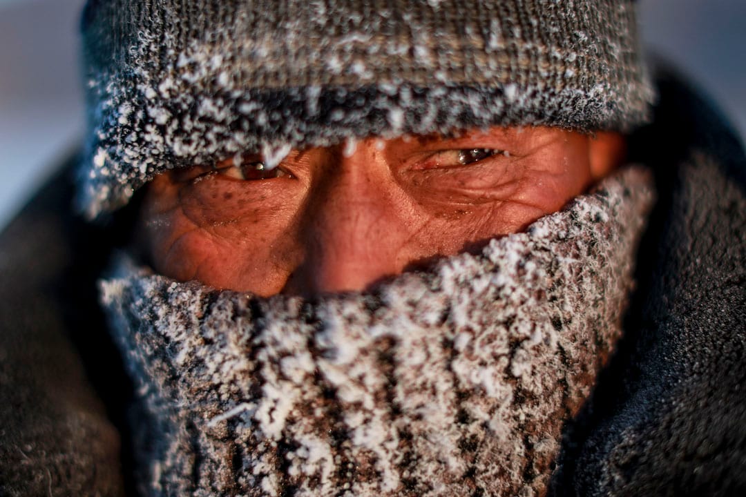 渔民保暖的面罩结满冰霜。