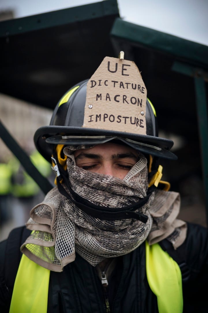 27岁工程师Theo特意从阿尔卑斯回到巴黎参加示威，他戴著的消防头盔上，写著他对欧盟、独裁主义及法国总统马克龙不满的字句。