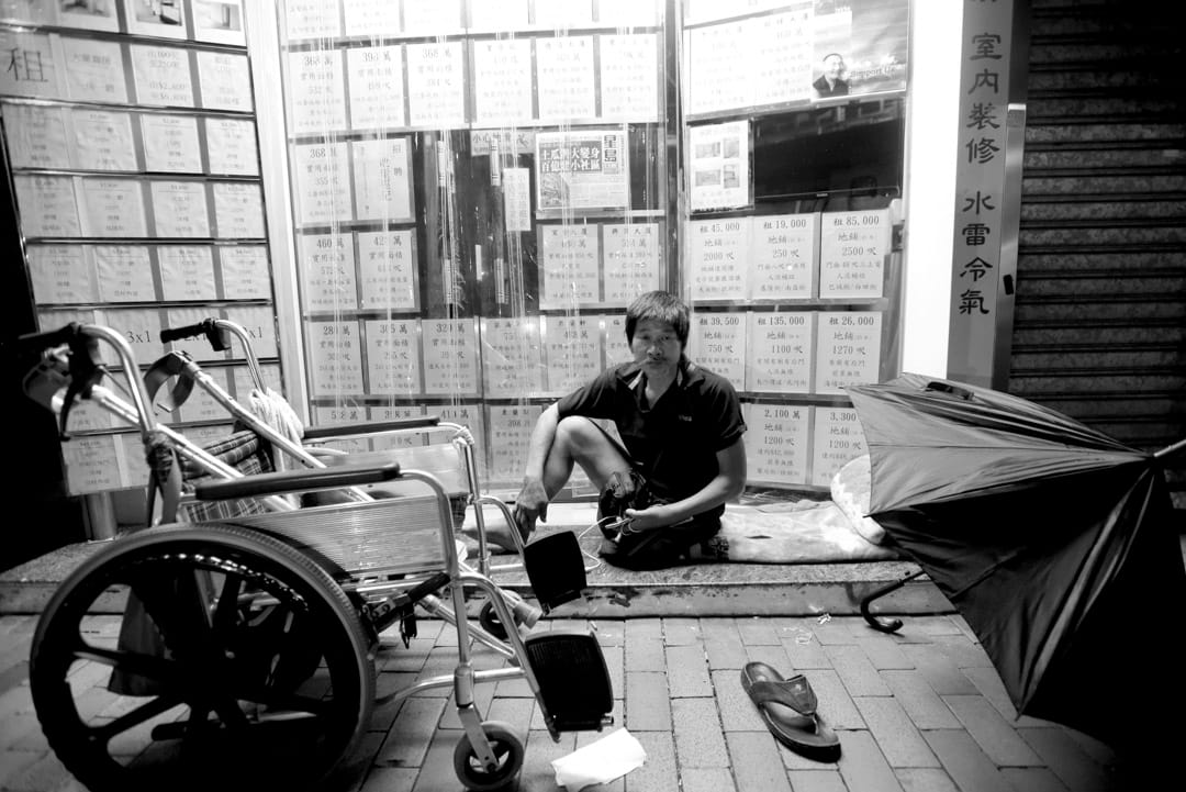 坐輪椅的發哥，因為租唔起地產舖門口廣告的4500蚊月租有電梯的劏房，他唯有瞓在地產舖門前「發個好夢」。