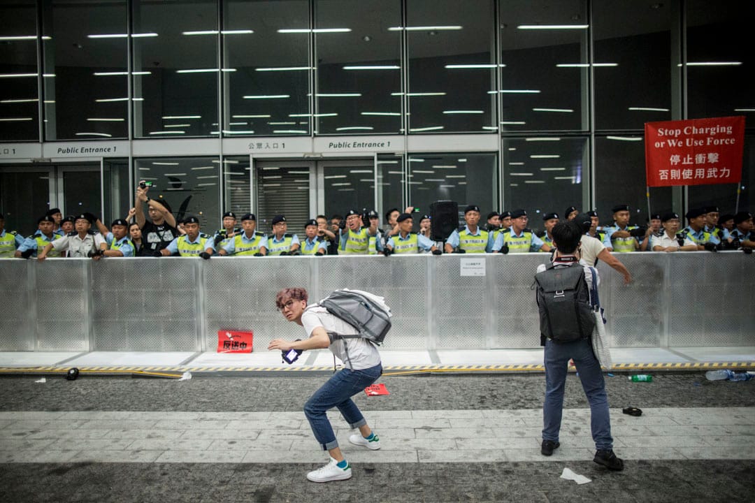 00:09，示威者向警方投掷物品。