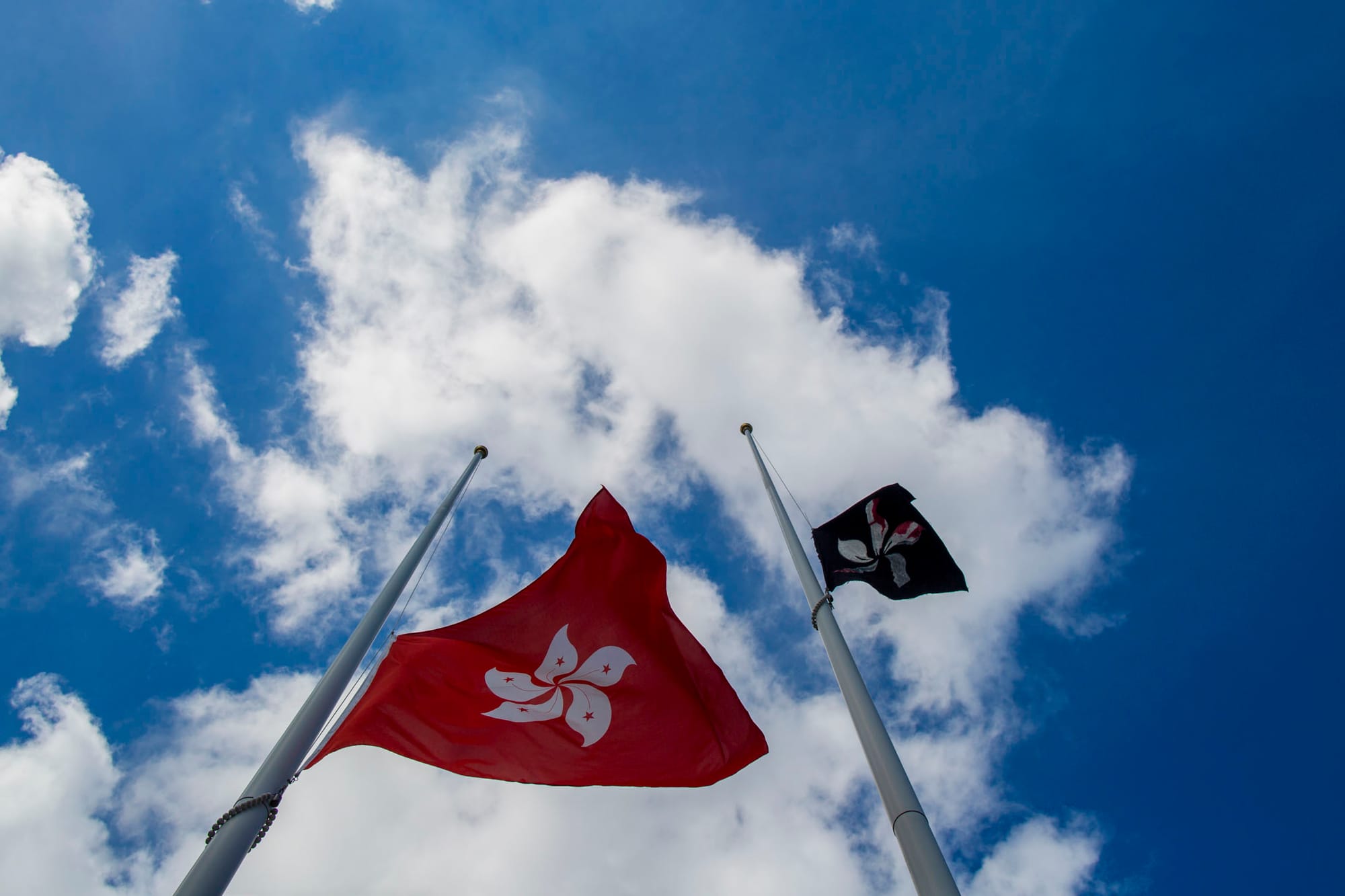 2019年7月1日，立法会广场外旗杆上悬挂的国旗被人换上黑旗，特区区旗则被下半旗。